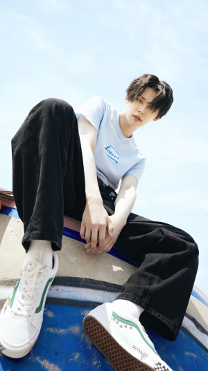 Yeonjun from TXT wearing a light blue t-shirt and black pants