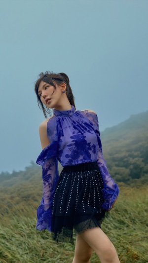 Wendy from Red Velvet in a purple top and black skirt