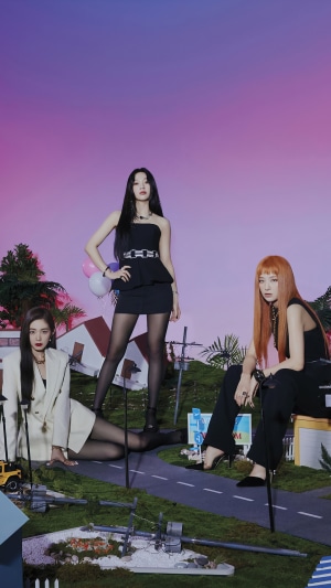 Red Velvet members posing in a miniature town setting