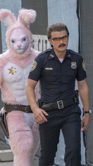 Joe Keery as Officer Reeves and a person in a pink bunny costume from Free Guy