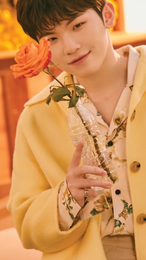 Woozi from Seventeen holding a rose in a vase