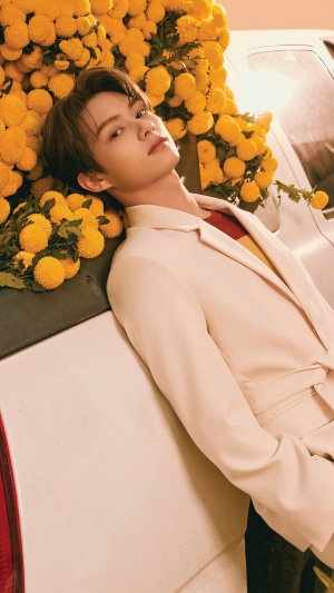 Jun from Seventeen posing with yellow flowers