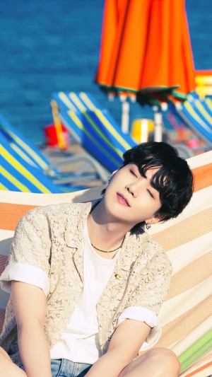 Suga from BTS relaxing on a beach hammock