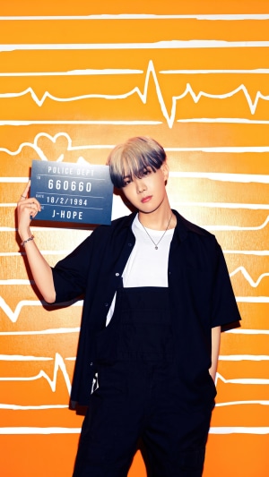 J-Hope from BTS holding a mugshot sign