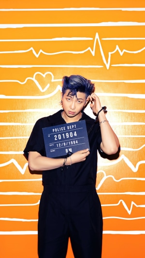 RM from BTS holding a mugshot sign