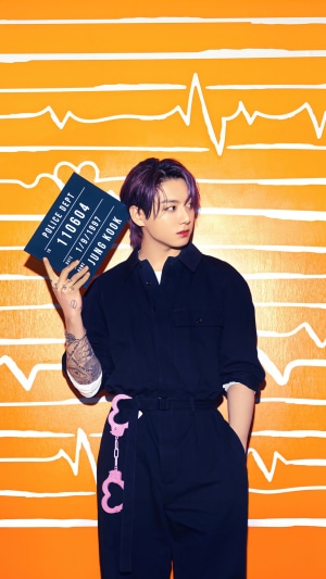 Jungkook from BTS holding a mugshot sign