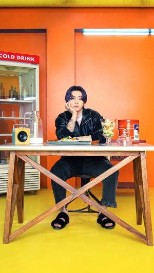 Jungkook from BTS sitting at a table