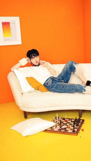Suga from BTS on a couch with a chessboard