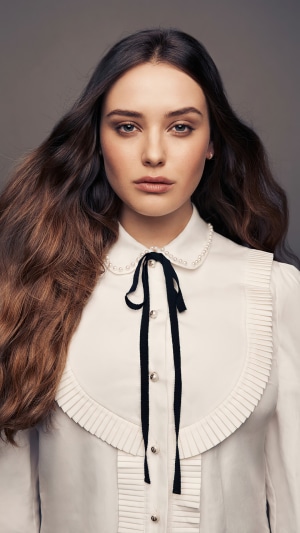 Katherine Langford wearing a white blouse with black ribbon