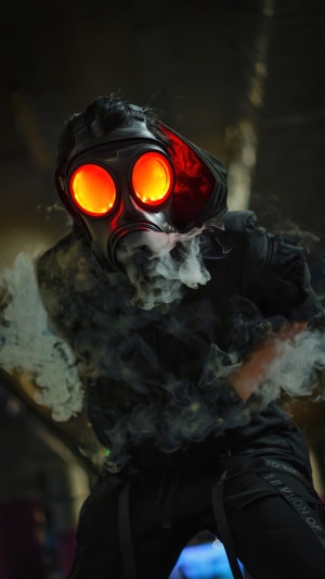 Person in gas mask with glowing red eyes and smoke