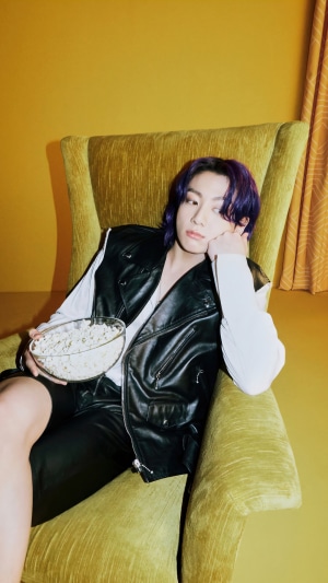Jungkook from BTS holding popcorn in a chair