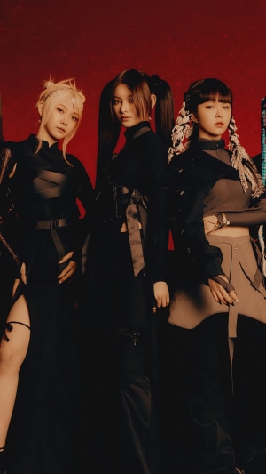 EVERGLOW members in dark outfits against red background