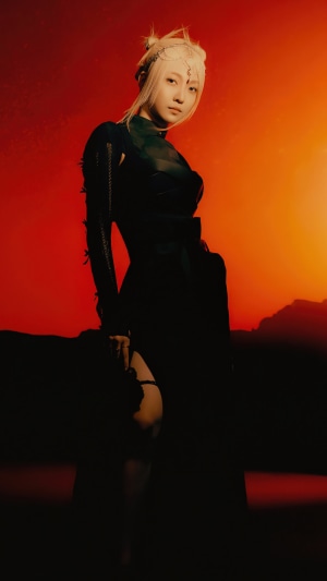 Onda from EVERGLOW in dark outfit against red background