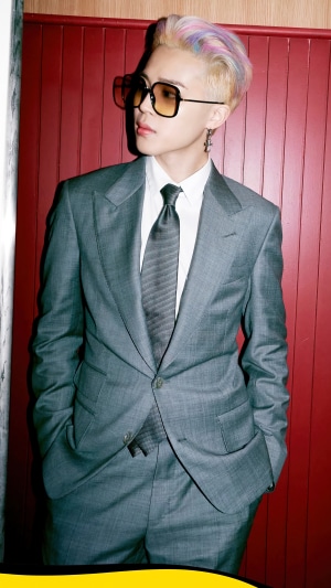 Jimin from BTS wearing a grey suit and sunglasses