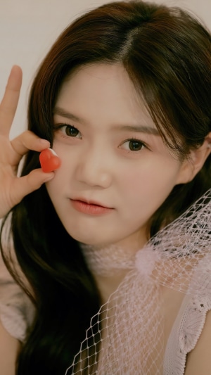 Hyojung from Oh My Girl holding a heart candy