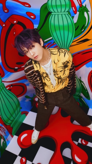 Jisung from NCT Dream in colorful, abstract setting