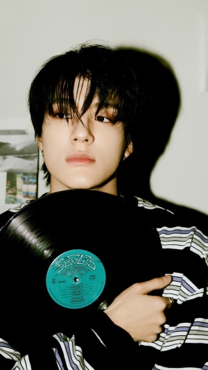 Jeno from NCT Dream holding a vinyl record