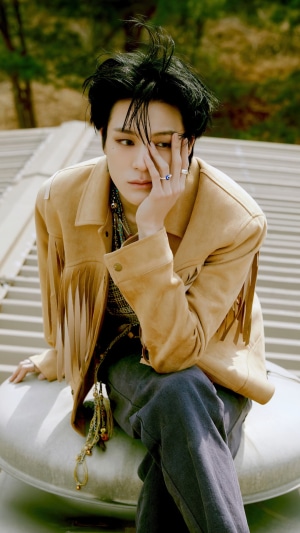 Jeno from NCT Dream sitting outdoors