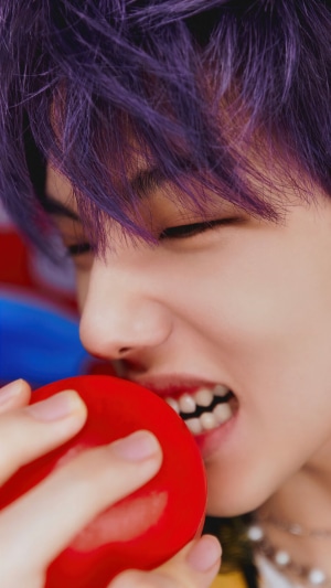 NCT Dream's Jisung biting a red object