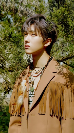 Jisung from NCT Dream in a brown fringed jacket