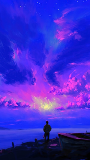 Man watching a colorful sunrise over the ocean