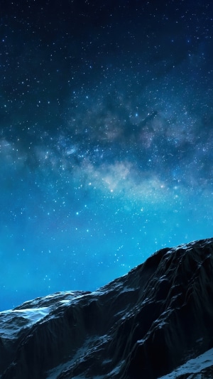 Starry night sky over a rocky mountain