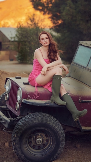 Madelaine Petsch sitting on a vintage jeep