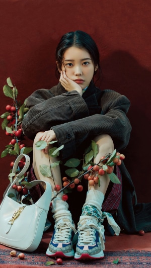 IU (Lee Ji Eun) sitting with fruit branches and a handbag