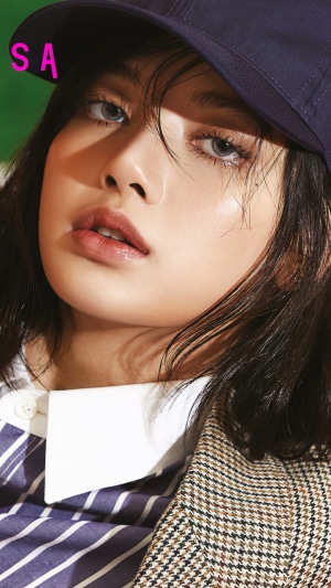 Lisa from BLACKPINK wearing a cap and jacket