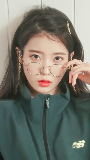 IU (Lee Ji Eun) wearing glasses and a green jacket