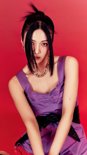 Joy from Red Velvet posing against a red background