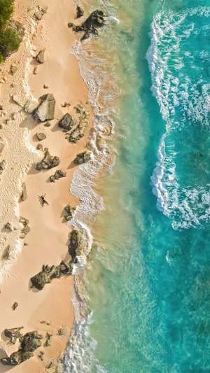 Aerial view of a tropical beach with turquoise ocean waves