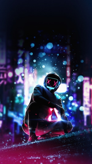 Man with glowing mask crouching in city at night