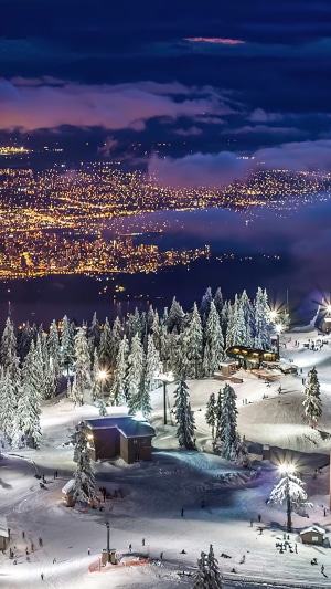 Vancouver city lights seen from a snowy ski resort at night