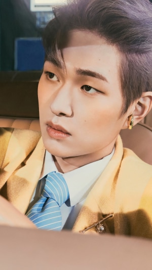 Onew from Shinee wearing a yellow suit and blue tie