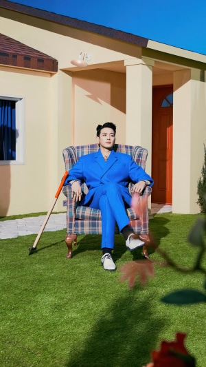 Minho from Shinee sitting in a chair outdoors