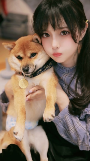 Young Asian girl holding a Shiba Inu dog