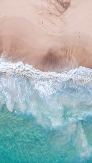 Aerial view of a sandy beach with ocean waves