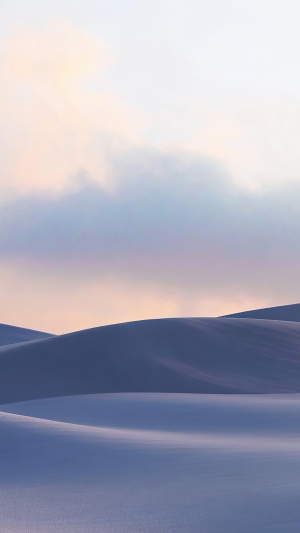 Rolling sand dunes under a pastel sky