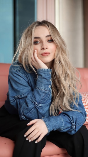 Sabrina Carpenter in a denim shirt and black pants