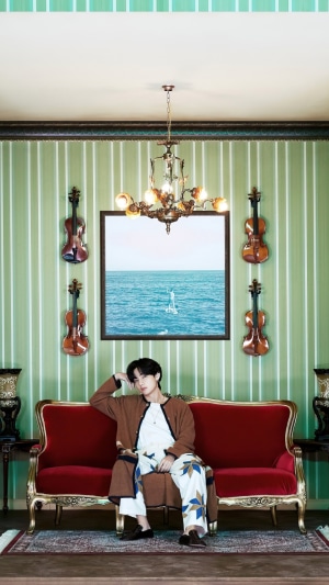 V from BTS sitting on a couch