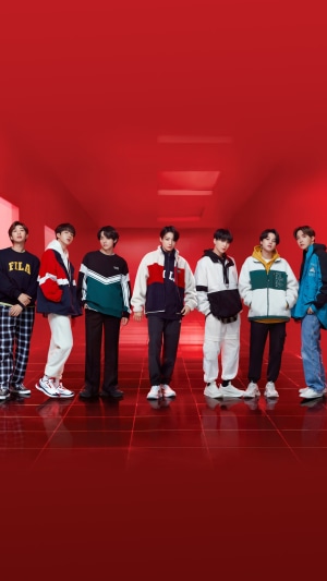 BTS members posing in a red hallway