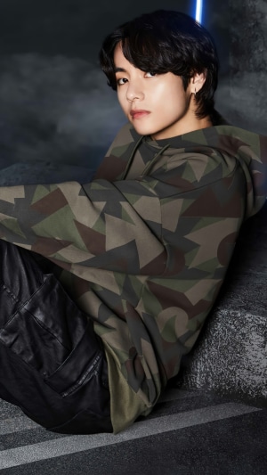 V from BTS in a camouflage hoodie