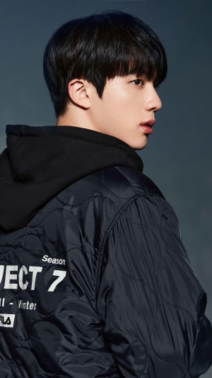 Jin from BTS wearing a Fila jacket