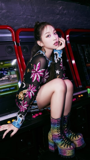 Dita from Secret Number posing by arcade machines