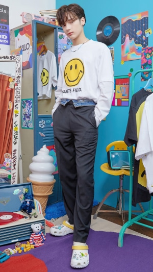 Huening Kai from TXT wearing a smiley face shirt