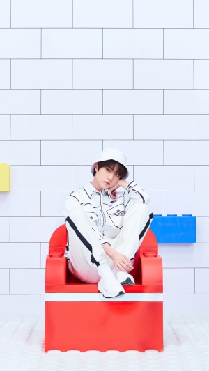 Beomgyu from TXT sitting on a red chair