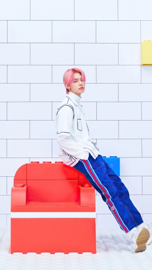 Yeonjun from TXT sitting on a red lego chair