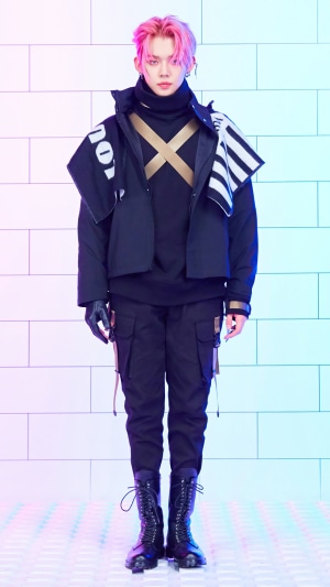 Yeonjun from TXT wearing a black jacket and cargo pants