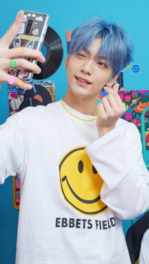 Soobin from TXT taking a selfie with blue hair